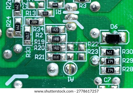 Macro close up of electronic circuit board with resistors and soldered components technology background