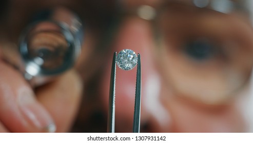 
Macro close up of experienced goldsmith controlling a quality of diamond stone, selected for making jewels in workshop. Concept of jewelry,luxury,goldsmith, diamonds, brilliance.
