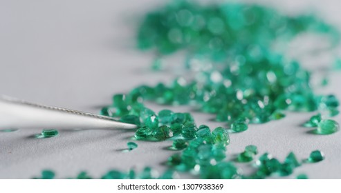 Macro close up of experienced goldsmith sorting high quality coloured green diamonds, selecting them to make precious jewels in workshop.Concept of jewelry,luxury,goldsmith, diamonds, brilliance.