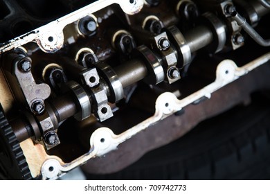 Macro Close Up Of An Exposed Metal Crank Shaft And Gears Of An Internal Combustion Engine, Lubricated With Dark Dirty Oil, In An Automotive Repair Shop