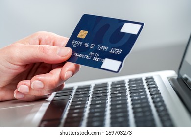 Macro Close Up Of Female Hand Holding Credit Card On Laptop.