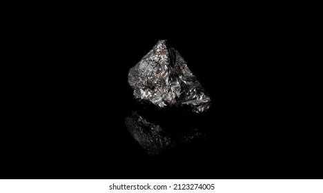 Macro Close Up Image Of Raw Material Manganese Ore Rock Isolated On Black Reflective Background