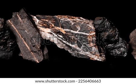 Macro Close up image of raw material Manganese Ore rock isolated on black reflective background