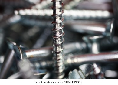 Macro close up of isolated pile metal crosshead screws in tool box (focus on center of bold thread)