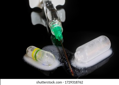 Macro Close Up Of Isolated Syringe With Injection Needle, Broken Glass Vial And White Liquid, Black Reflecting Background (selective Focus On Center)