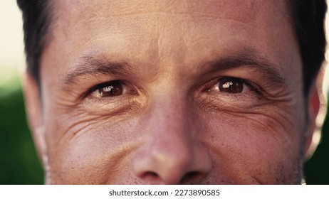 Macro close up of a man in 40s looking at camera smiling with wrinkles - Powered by Shutterstock