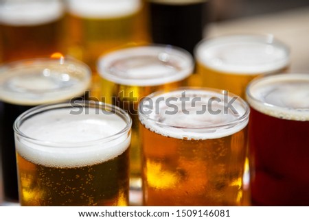 Macro close up on a flight of craft beer in small taster glasses, with space for text on top