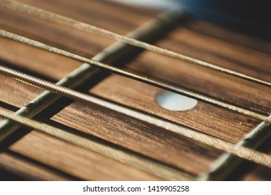 Macro close up shot of acoustic guitar strings on sun shine. Music and guitar playing concept