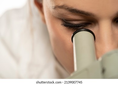 Macro Close Up Shot Of A Female Scientist Looking Into The Microscope. White Background