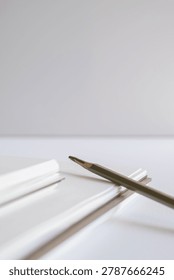 Macro close up of spiral notebook binding and layered paper edges on white background in studio. Minimal stationery, publishing detail, modern branding, clean texture, creative workspace.