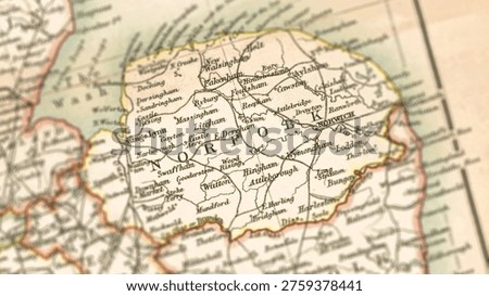 Macro close up of a vintage map highlighting Norfolk in England, United Kingdom, showcasing detailed cartography, major towns, coastal geography, and classic antique textures ideal for travel, geography, and historical themes.