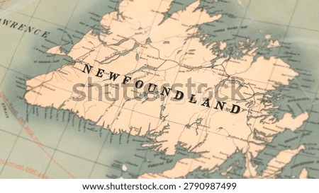Macro close up of a vintage map highlighting Newfoundland in Canada, showcasing detailed cartography, coastal settlements, Atlantic geography, and classic antique textures ideal for travel, history, and navigation themes.