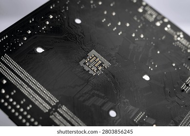 Macro close-up of the back side of a computer motherboard featuring printed circuit board traces and electronic solder points, representing PCB engineering, digital technology, hardware design and electronics manufacturing.
