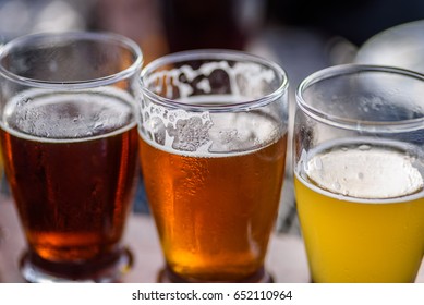 Macro Closeup Of Colorful Beer Flight Glasses Outside In Sunlight At Microbrew Beer Garden In Summer