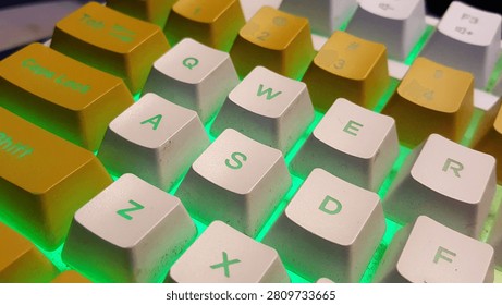 A macro close-up of a custom mechanical keyboard focusing on the prominent orange Enter key and white Shift key. Illuminated by a vibrant neon purple and pink RGB LED backlight, this colorful peripheral layout represents digital execution, computer programming, cybersecurity, and modern gaming setups.