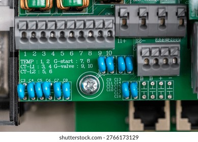 Macro close-up of an electrical control board inside a solar battery system, showing terminals, connectors, capacitors and wiring. Detailed view of renewable energy infrastructure and electronic components used for power distribution and energy storage. Ideal for concepts of solar technology, engineering, electronics and sustainable energy systems.