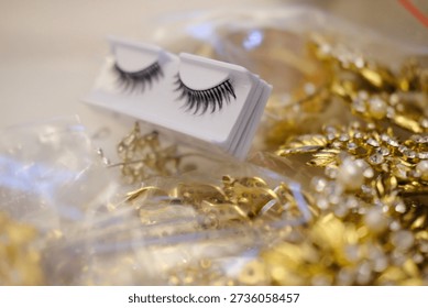 Macro close-up of false eyelashes in packaging with golden sparkling background. Ideal for bridal makeup, glam fashion, salon advertising and beauty branding.