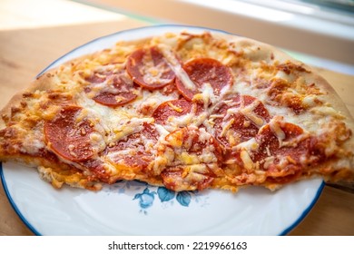 Macro Closeup Of Fresh Thin Crust Half Pizza On White Plate With Melted Mozzarella Cheese, Pepperoni Meat Slices Of Unhealthy Greasy Food