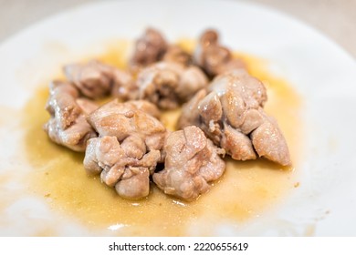 Macro closeup of fresh whole cooked fried beef sweetbreads thymus organ gland, nutritious ancestral meat homemade food on white plate on kitchen table