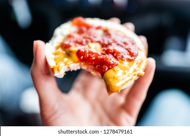 Macro closeup of hand holding one rice cake in car road trip blurry background topped with peanut butter, strawberry jam, vegan dessert snack - Powered by Shutterstock