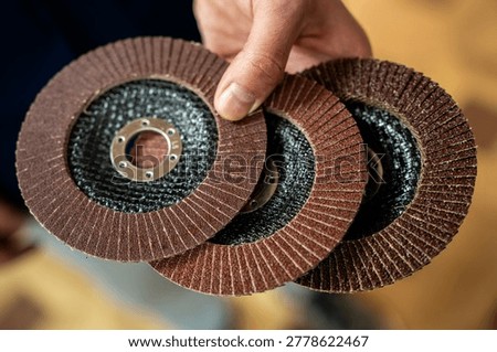 Macro close-up of layered flap abrasive discs, showing rough sanding material and circular metal center for grinding or surface finishing.