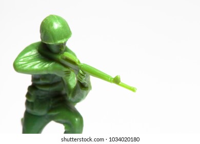 Macro Closeup Of Little Green Army Men Toys - Military Soldier Firing A Machine Gun - Focus On Gun