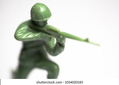 Macro Closeup Of Little Green Army Men Toys - Military Soldier Firing A Machine Gun - Focus On Face