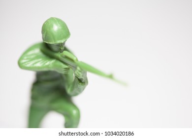 Macro Closeup Of Little Green Army Men Toys - Military Soldier Firing A Machine Gun - Focus On Face