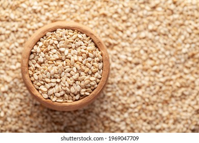 Macro Close-up of Organic White Sesame seeds(Sesamum indicum) or white Til in an earthen clay pot (kulhar) on the self background. Top view
				