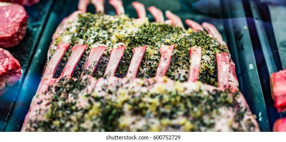 Macro closeup of raw lamb chops with green herbs