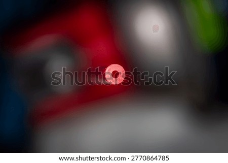 
Macro closeup of red plastic straw opening with shallow depth of field and abstract blurred background showing circular form and texture