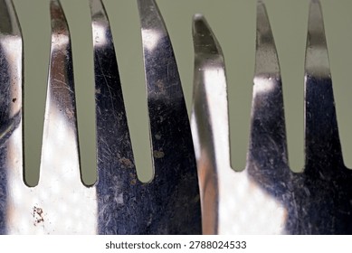 Macro close-up of reflective metallic fork prongs arranged in an abstract composition                              
