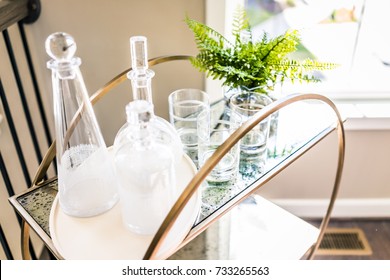 Macro closeup of serving tray stand with empty glasses and plant in staging model house, home or apartment