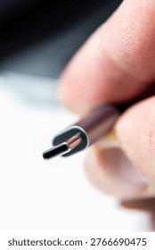 A macro close-up shows a USB Type C connector held between fingers against a soft background.