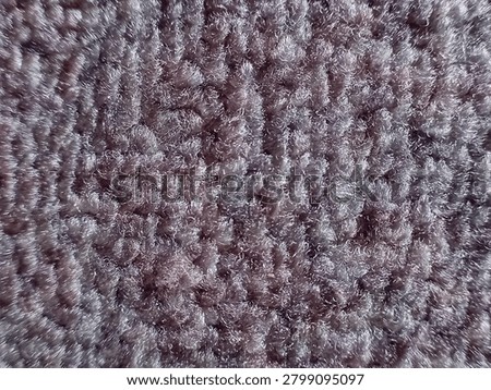 Macro close-up texture of grayish purple synthetic loop pile carpet or rug with detailed fibers and soft sheen