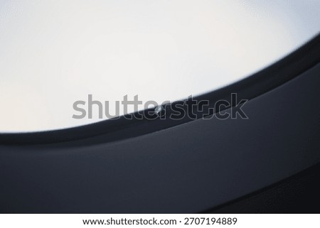 Macro close-up of the tiny breather hole in an airplane window.