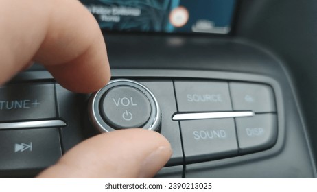 Macro close-up, turning down the volume of the car radio. - Powered by Shutterstock