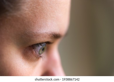 Macro closeup of young woman face portrait in profile side with Grave's disease hyperthyroidism symptoms of ophthalmopathy bulging eyes proptosis edema