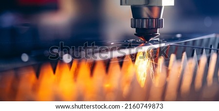 Macro CNC laser machine cutting sheet metal with light spark. Technology plasma industrial banner, Blue steel color.