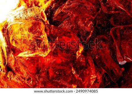macro cola background,Cola with Ice. Close up of the ice cubes in cola water. Texture of carbonate drink with bubbles in glass. Cola soda and ice splashing fizzing or floating up to top of