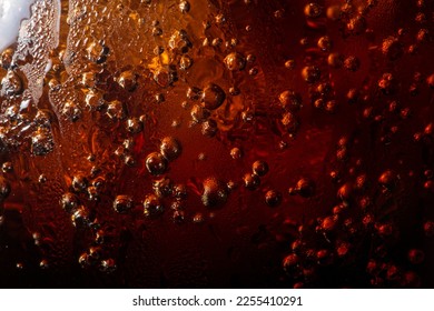 macro cola drink texture,macro soft drink texture,Close up view of ice cubes in dark cola background. Textures of sweet summer cold drinks with foam and macro bubbles on Fizzing glass wall.