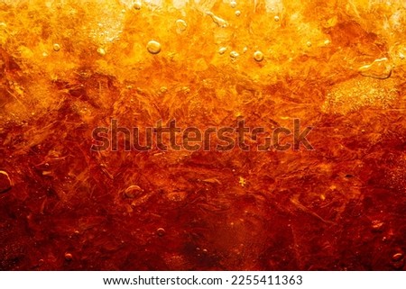 macro cola drink texture,macro soft drink texture,Close up view of ice cubes in dark cola background. Textures of sweet summer cold drinks with foam and macro bubbles on Fizzing glass wall.