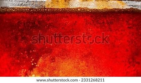 macro cola texture,Close up view of the ice cubes in dark cola background. Texture of cooling sweet summer's drink with foam and macro bubbles on the glass wall. Fizzing or floating up to top of surfa