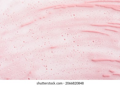 Macro Cosmetic Foam With Bubbles On Pink Surface. Texture Lather Of Beauty Product For Skin Cleansing.