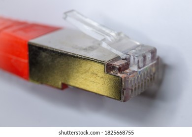 Macro cross section front angle view of red RJ45 CAT6 shielded network data internet cable clear connector on white background