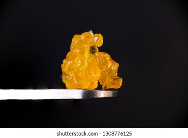 Macro detail of cannabis concentrate HTFSE extracted from medical marijuana isolated over black on a dabbing tool 