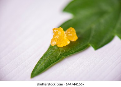 Macro detail of cannabis concentrate live resin extracted from medical marijuana on a pot leaf