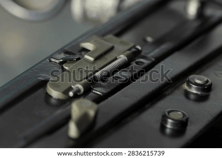 Macro detail of the safety catch and cocking mechanism of a British service rifle, machined metal and springs in shallow focus.