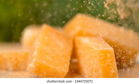 MACRO, DOF: Delicious Parmesan Cheese Is Sprinkled Over The Whole Squares. Mouth-watering Shot Of Parmesan Cheese Being Grated Over The Yellow Cubes. Tasty Cheese Is Being Served As Appetizer.