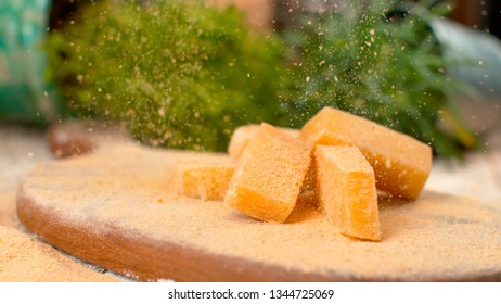MACRO, DOF: Fragrant Parmesan Flakes Fall On The Cheese Cubes On The Wooden Board. Mouth-watering Shot Of Sweet Parmesan Cheese Being Grated Over The Whole Cheese Cubes. Gourmet Delicacy From Italy.